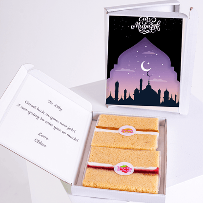 Eid Mubarak gift box with cake, Good luck message, and mosque illustration.