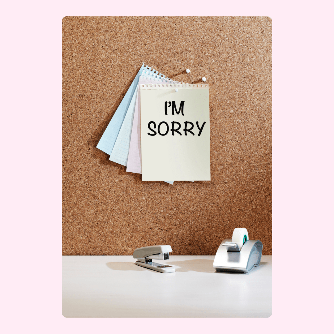 I'm sorry note on corkboard with stapler and tape dispenser.
