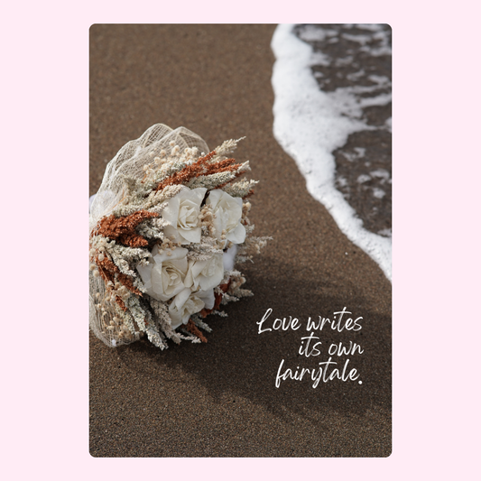 Wedding bouquet on beach with quote Love writes its own fairytale