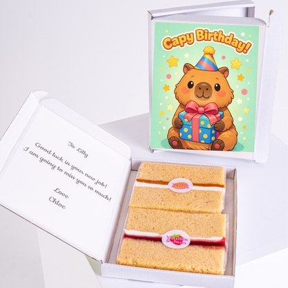 A cute capybara holding a birthday gift box, with a festive "Cappy Birthday!" card, personalized message, and two slices of cake in a box.